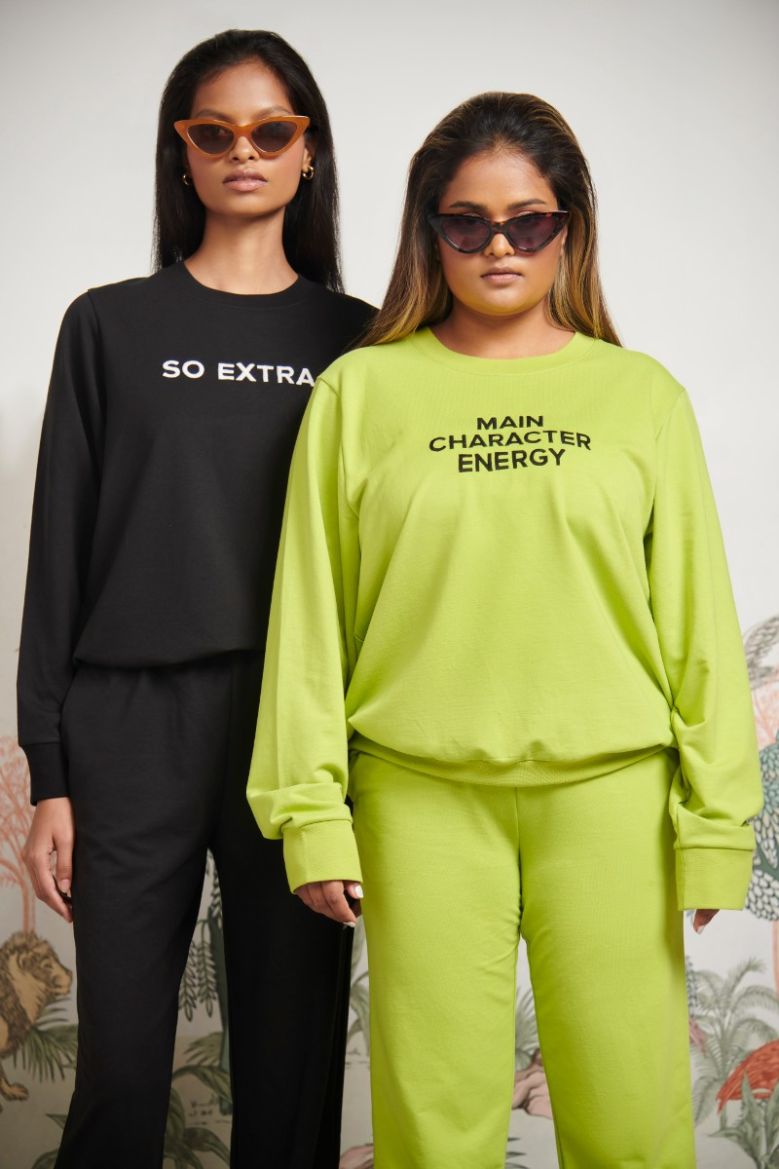 Two models wearing vibrant sweatshirts showcasing "Main Character Energy" style.