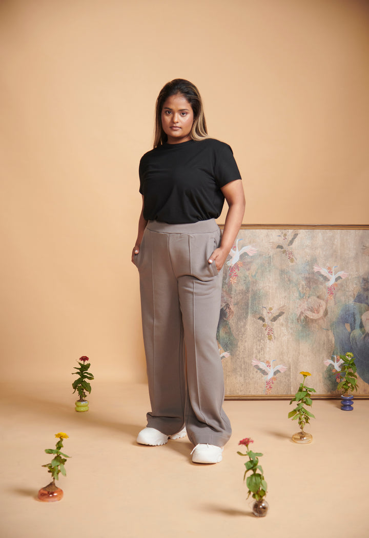 Model wearing grey terry travel set with floral decor backdrop.