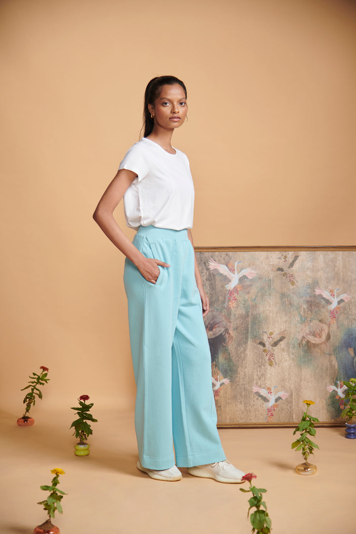 Model wearing blue terry high waist travel pant with pockets.