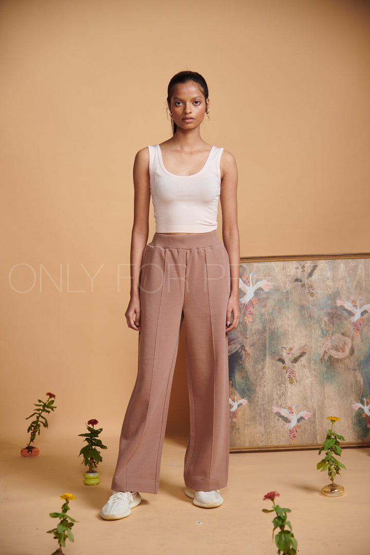 Light pink cropped vest styled with wide-leg pants in studio setting.