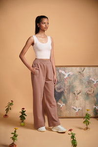Light pink cropped vest styled with relaxed pants and sneakers.