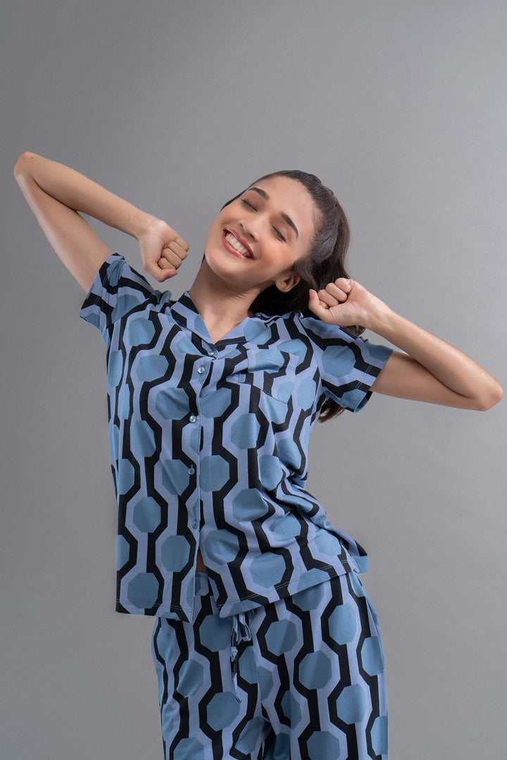 Smiling woman wearing midnight blue geometric dream pajama set.