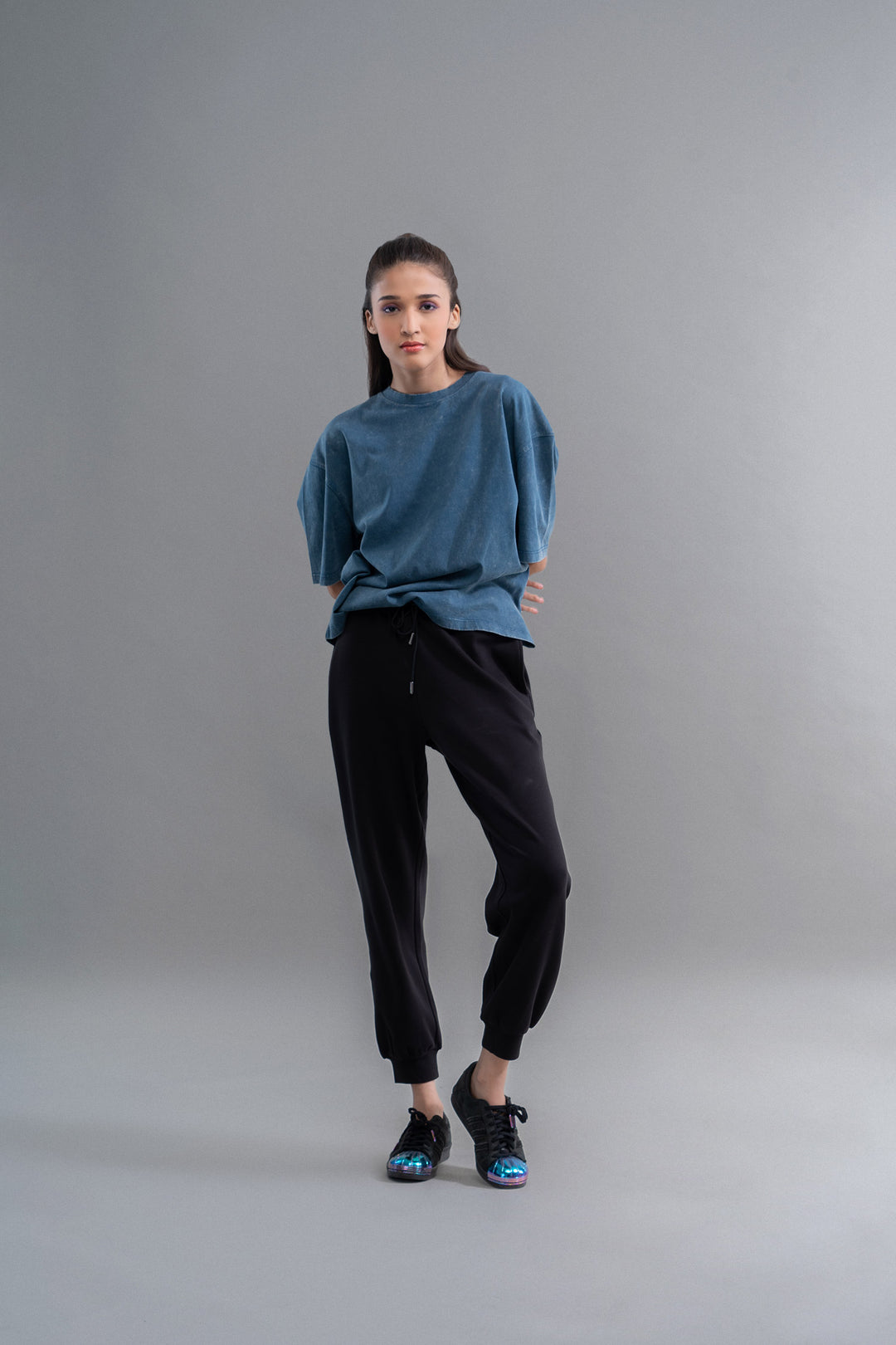 Teal acid wash unisex t-shirt worn with black joggers and sneakers.