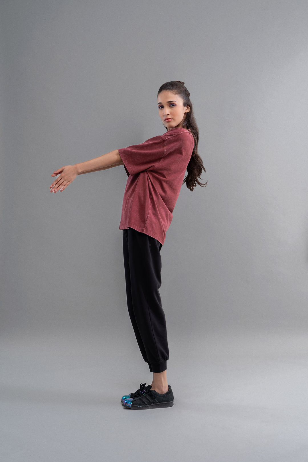 Burgundy acid wash unisex t-shirt styled with black pants and sneakers.