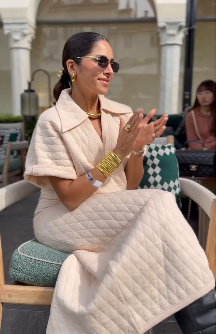 Trendy woman in quilted white skirt set, stylish accessories.