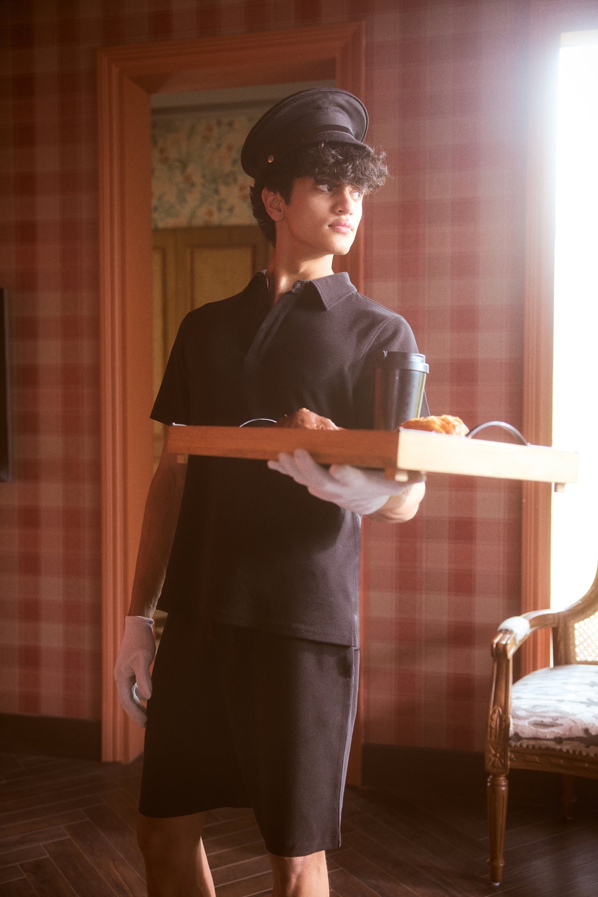Lushknit® Mens Polo modeled by a young man serving coffee and pastries.