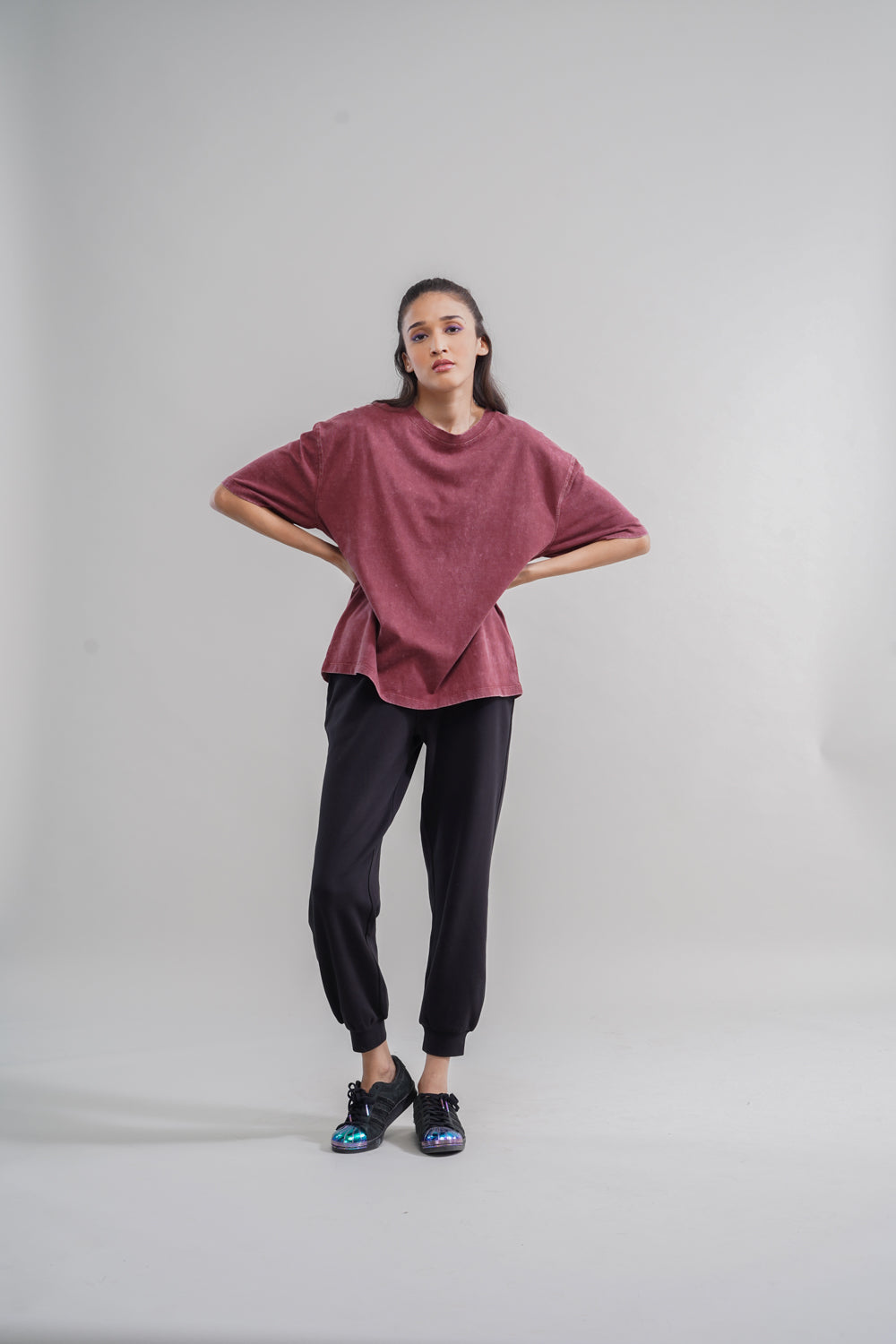 Acid wash unisex t-shirt worn with black pants and stylish sneakers.