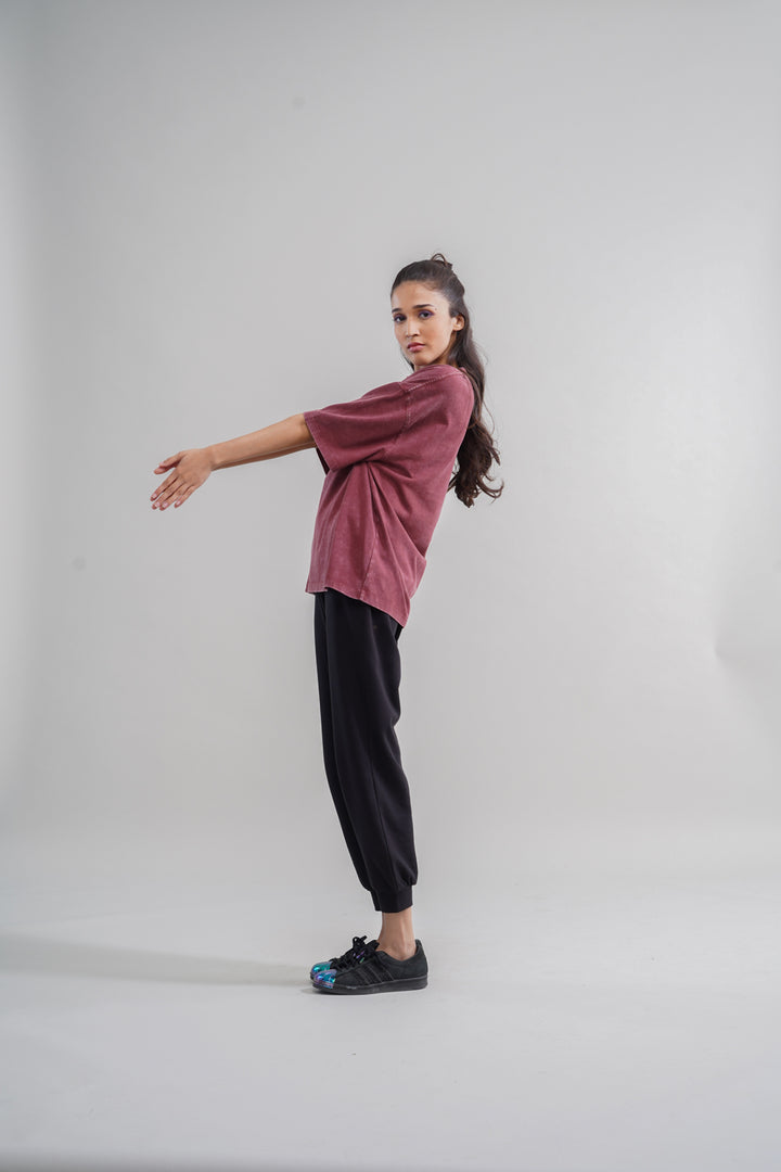 Rust acid wash unisex t-shirt worn by a model standing sideways.