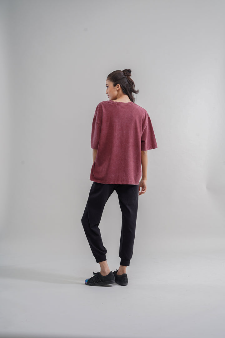 Rust acid wash unisex t-shirt displayed on model from the back.