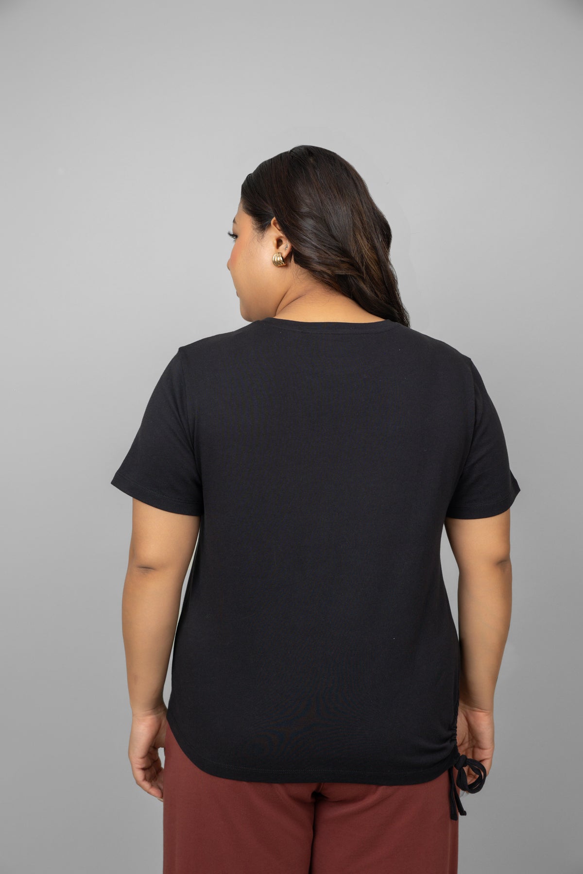 Black cotton t-shirt with side ruching detail, styled from the back.