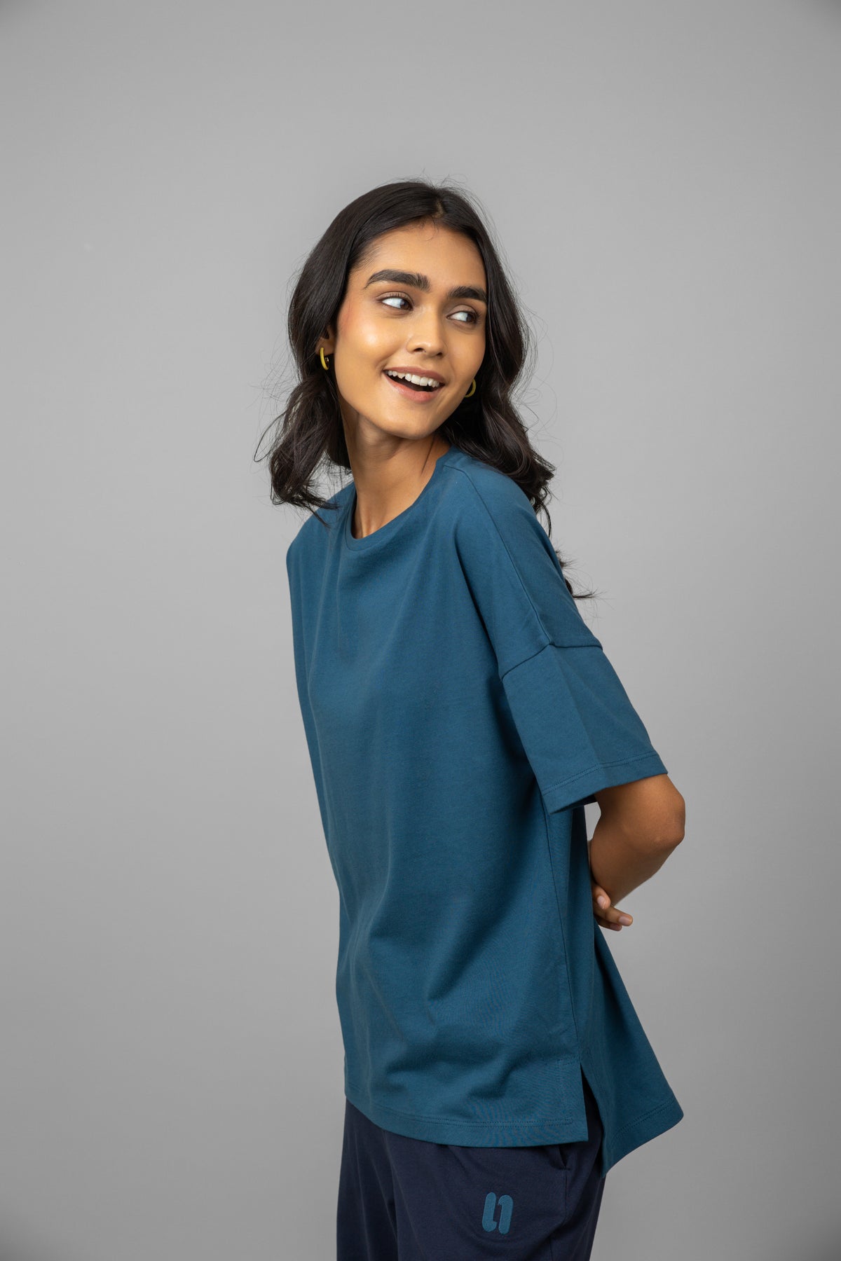 Model wearing a teal oversized cotton tee, showcasing relaxed style.