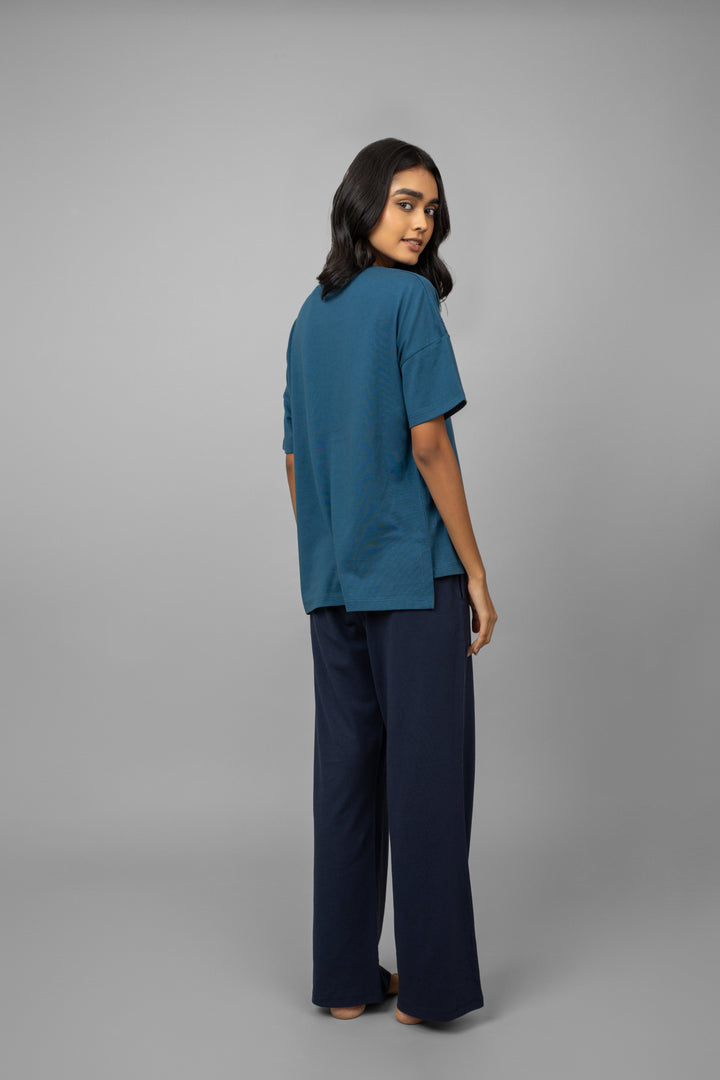 Teal top and navy logo pants set worn by model.