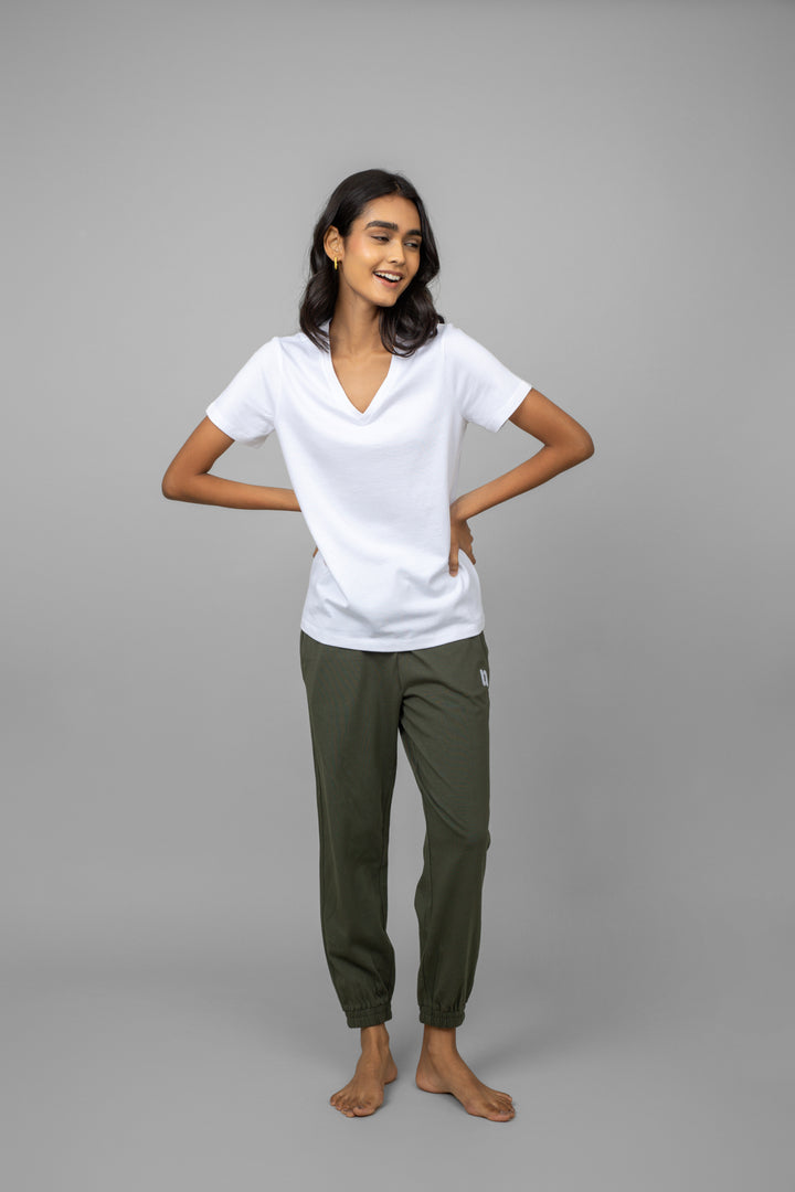 Model wearing a stylish white V-neck tee and green pants.