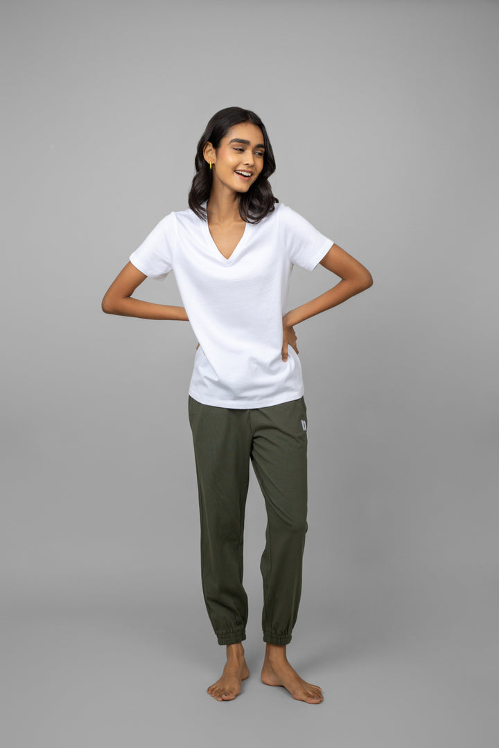 White V-neck jogger set with green pants, model smiling.