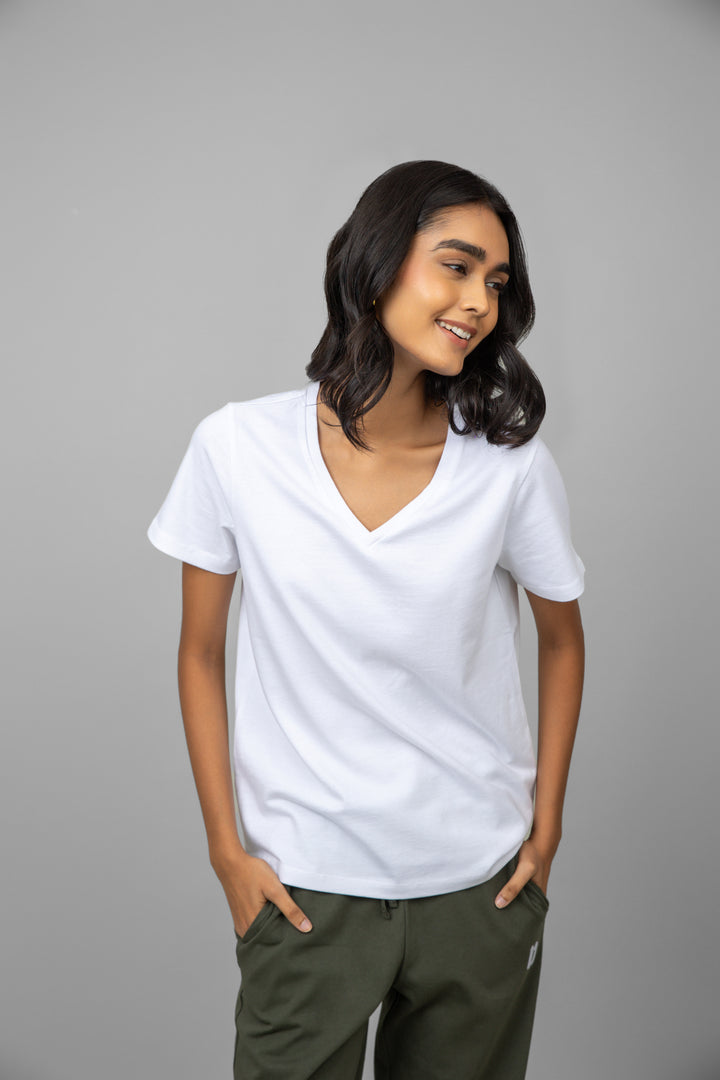 White V-neck jogger set modeled by smiling woman.