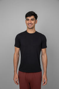 Black men's essential t-shirt displayed on a smiling model.