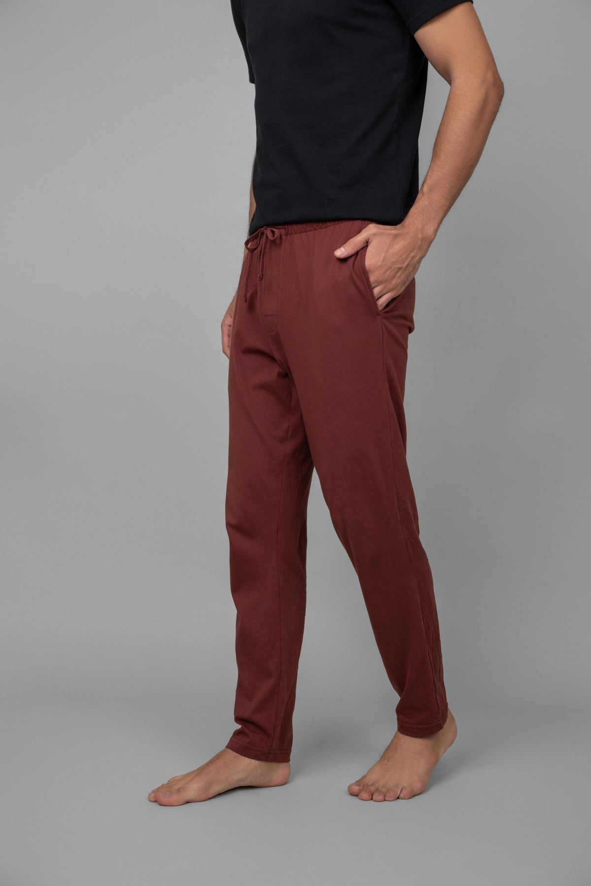 Burgundy men's pajama pants worn with a black shirt.