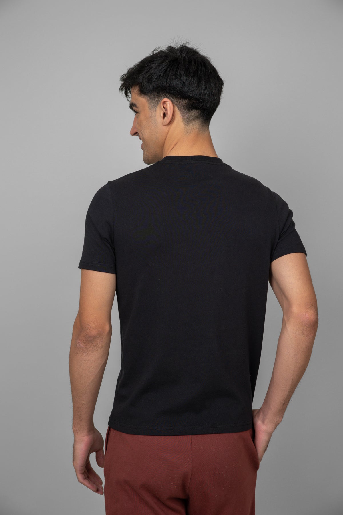 Black men's essential t-shirt displayed from the back.
