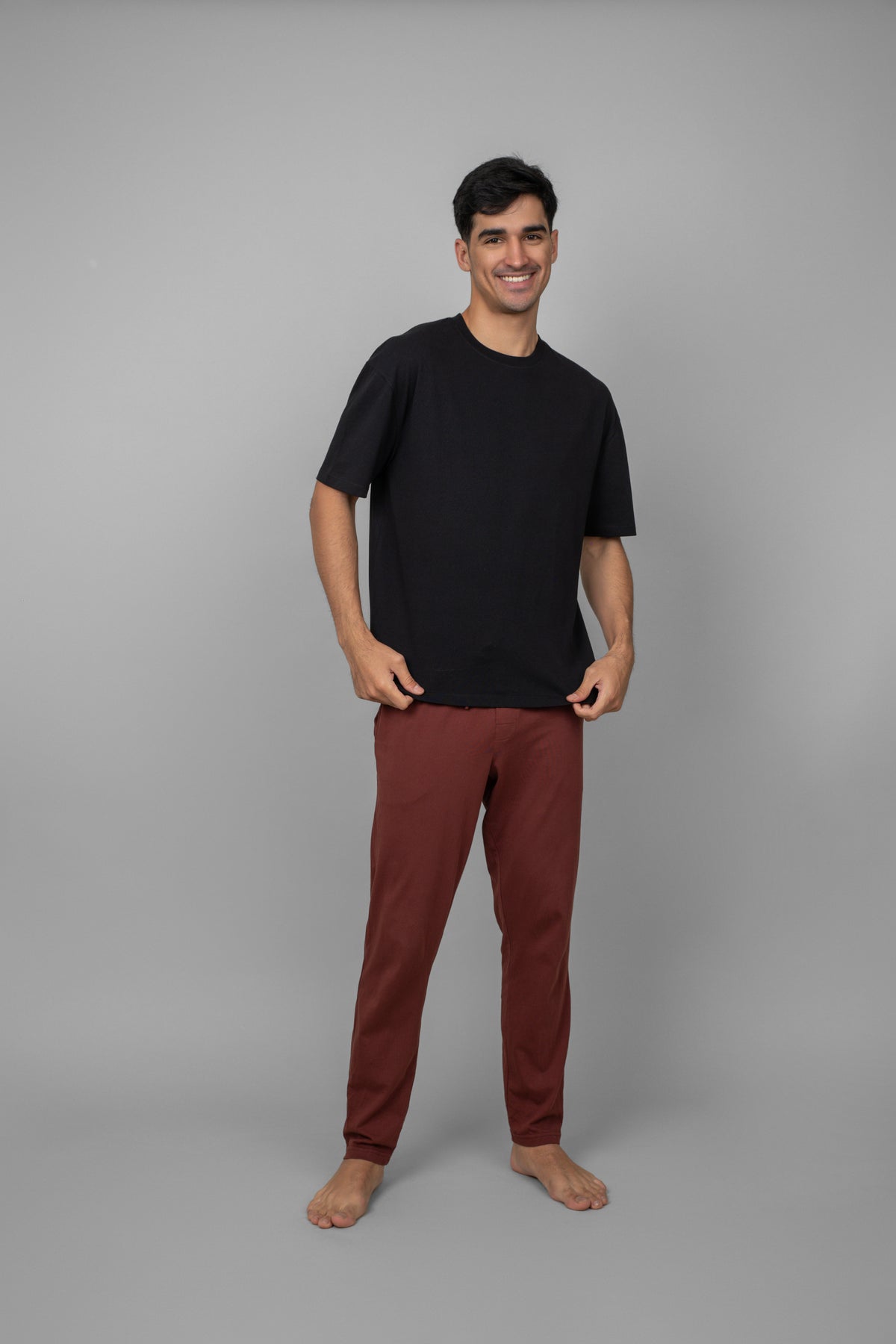 Model wearing a black oversized tee with brown pants.