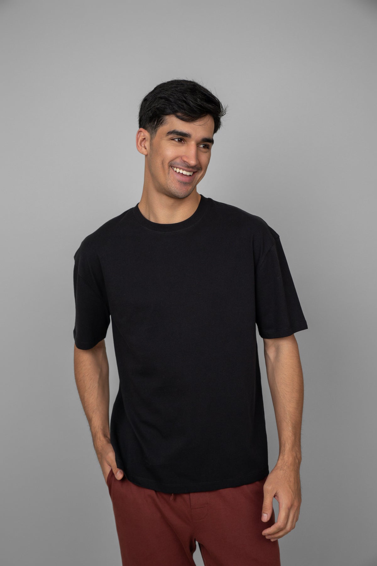Black men's essential T-shirt worn by smiling model.
