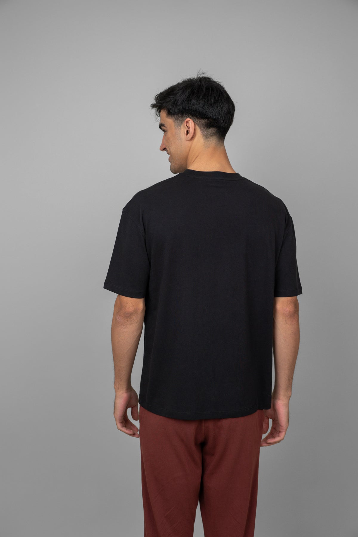 Black men's oversized tee, showcasing back view and relaxed fit.