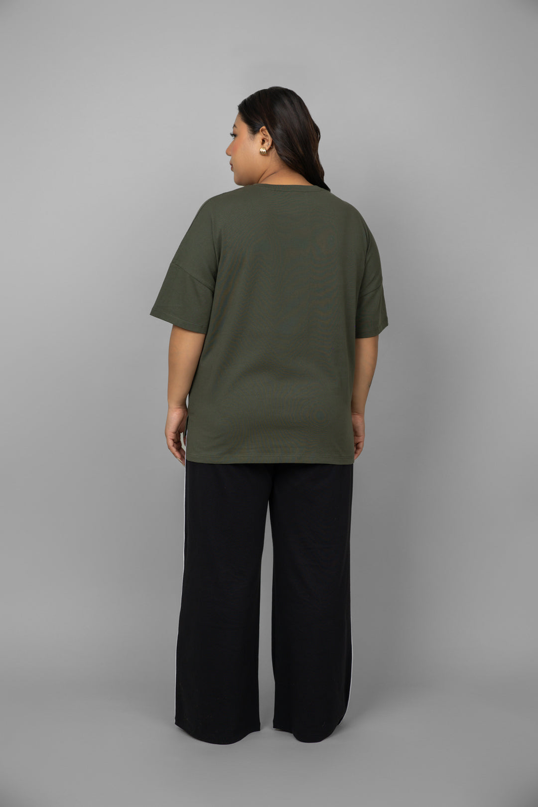 Back view of green top with black piping pants set.