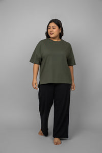 Green oversized cotton tee worn with black pants.