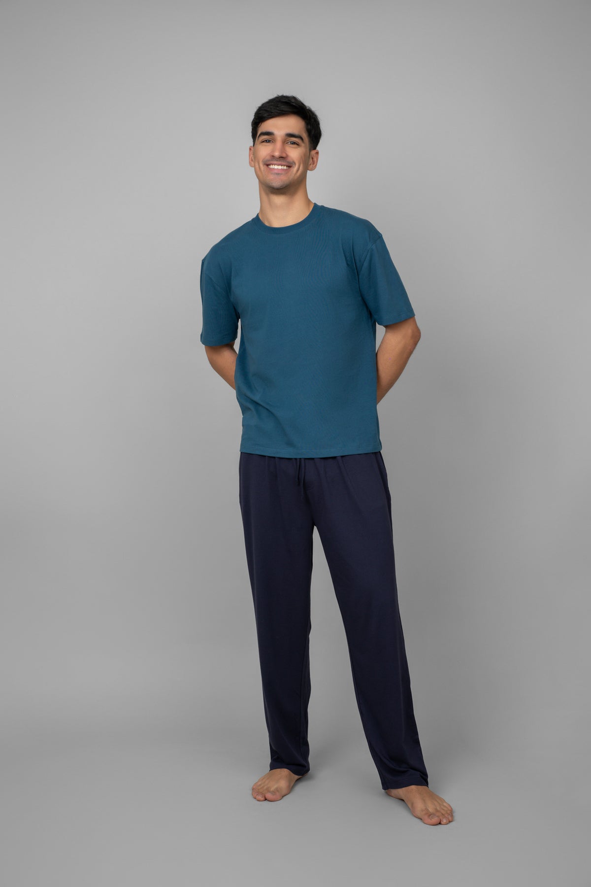 Blue men's oversized tee displayed on a smiling model.