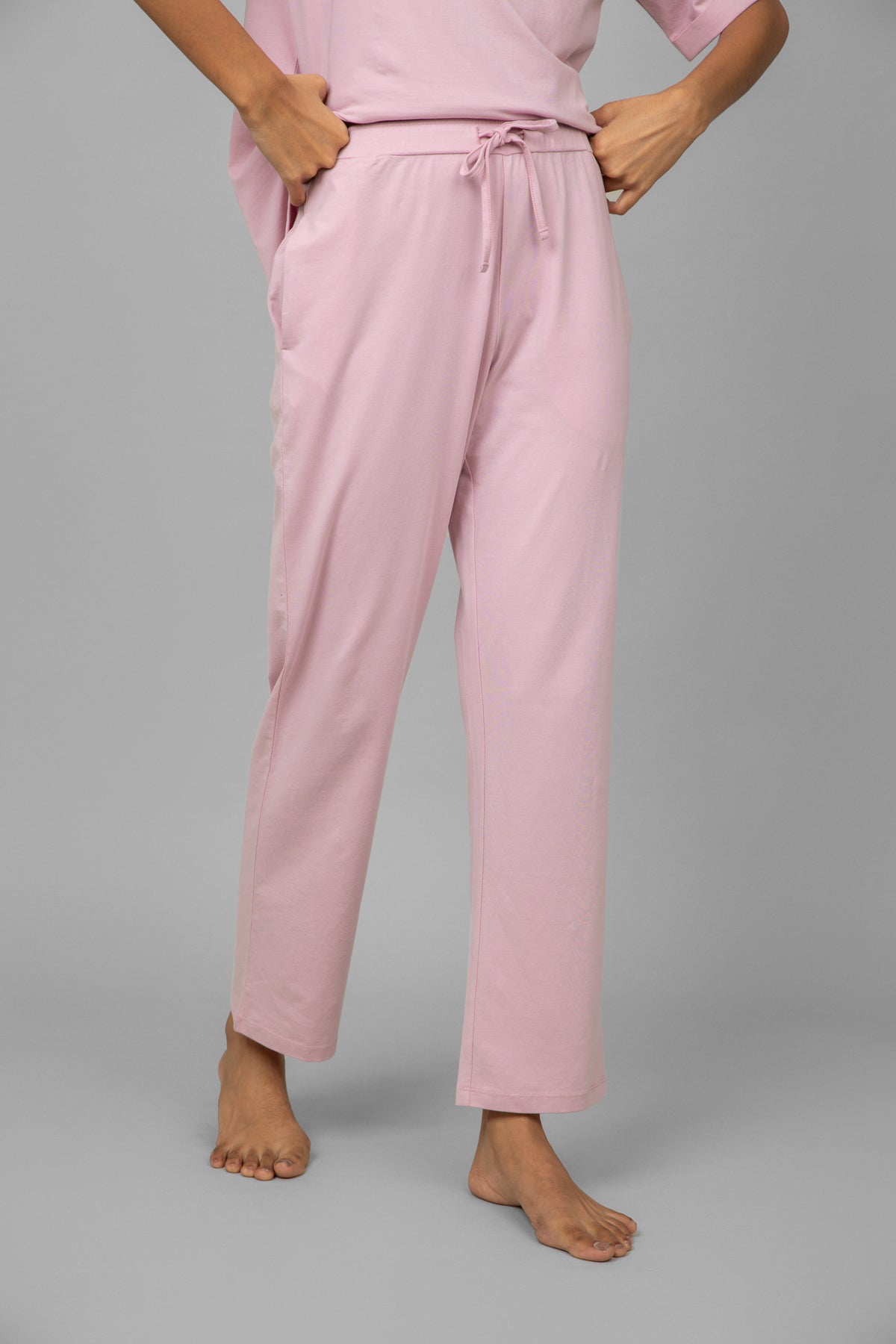 Blush pink lounge pants with drawstring waist and pockets.