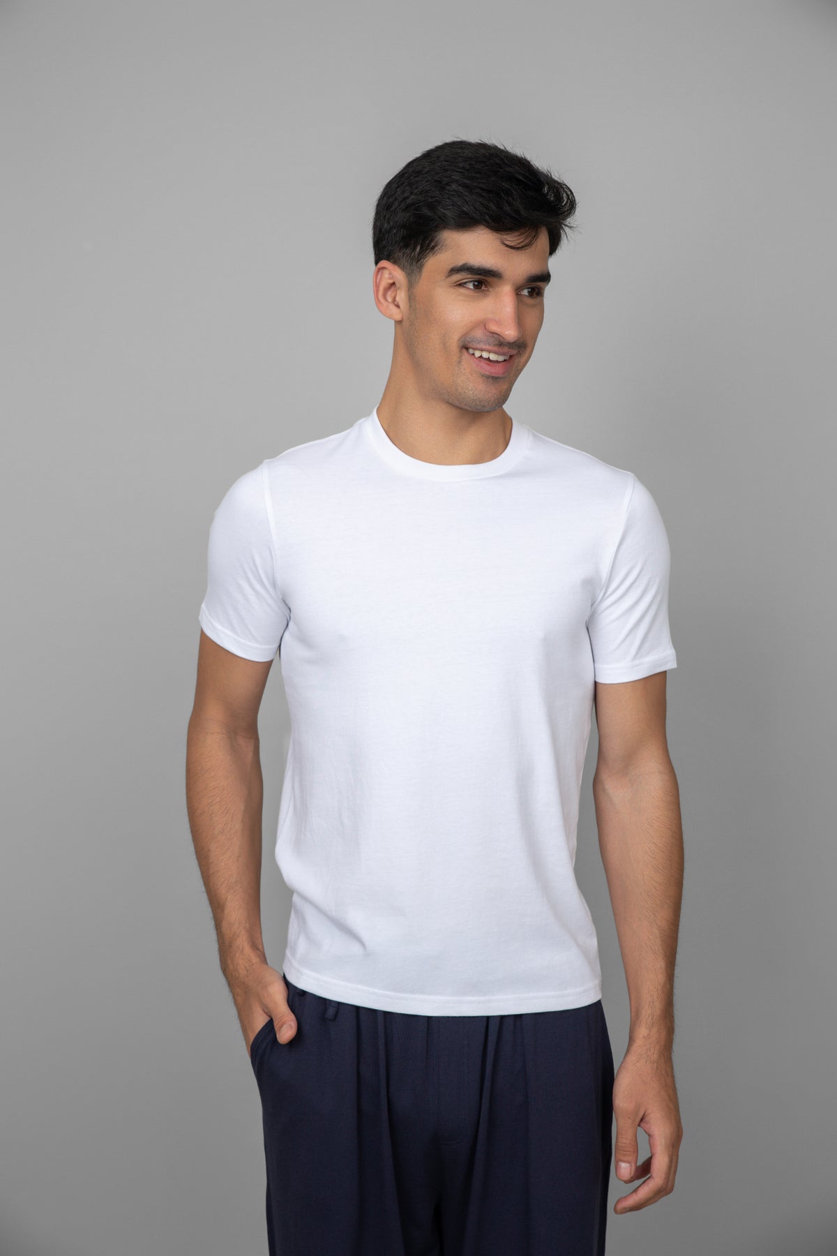 White men's essential t-shirt on model smiling in casual attire.