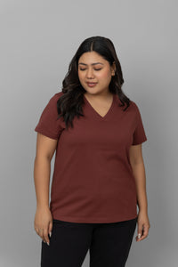 Rust V-neck tee styled with black pants on a model.