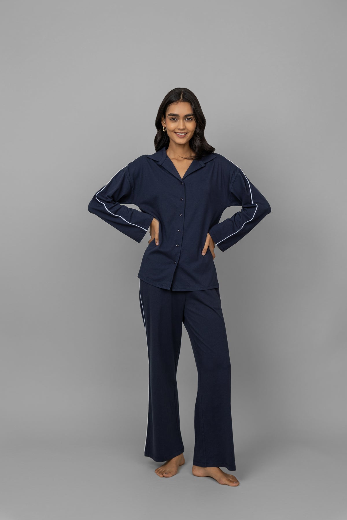 Navy button-down pajama set with white piping for stylish comfort.