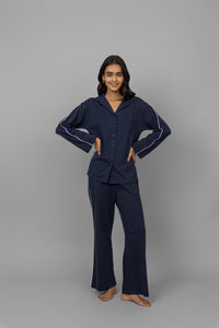 Navy button-down pajama set with white piping for stylish comfort.