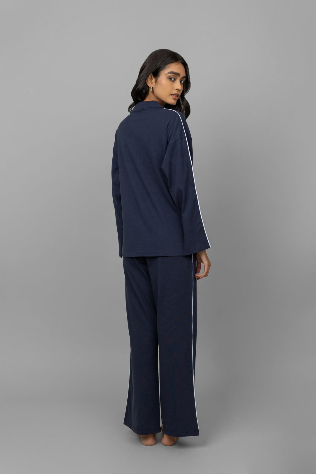 Navy button-down pajama set with white piping for stylish comfort.