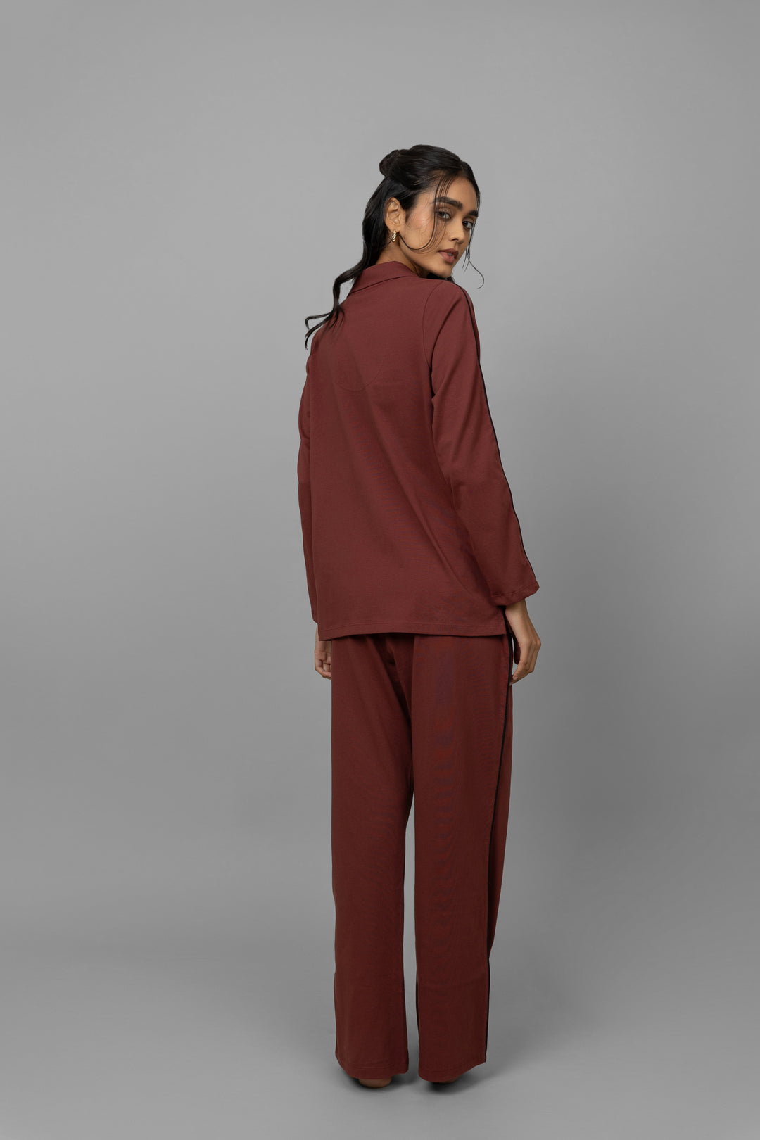 Model showcasing a ruby button down shirt, back view.
