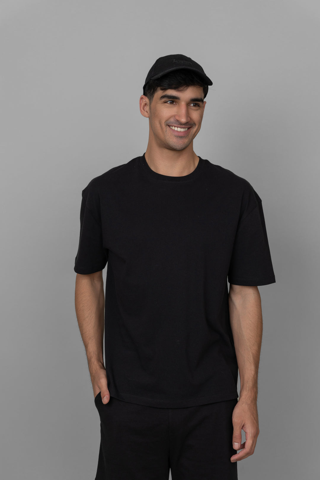 Black men's shorts set with casual t-shirt and cap, stylish outfit.