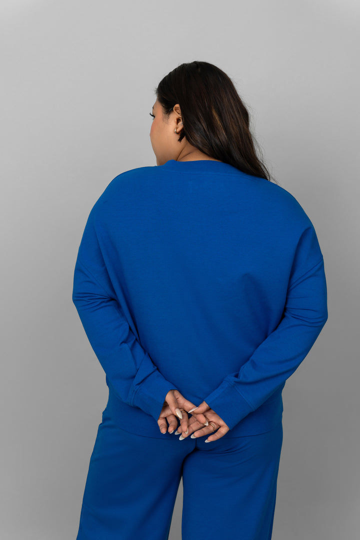 Woman wearing a blue bamboo terry sweatshirt from the back.