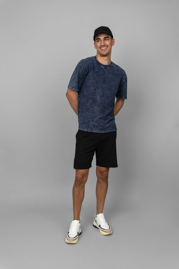 Navy acid wash unisex t-shirt styled with black shorts and sneakers.