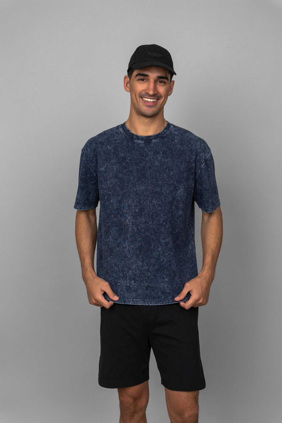 Black men's shorts paired with a stylish T-shirt and cap.