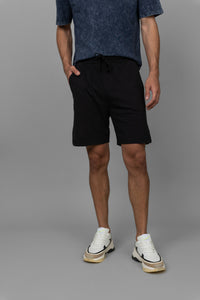Black men's shorts styled with a casual t-shirt and sneakers.