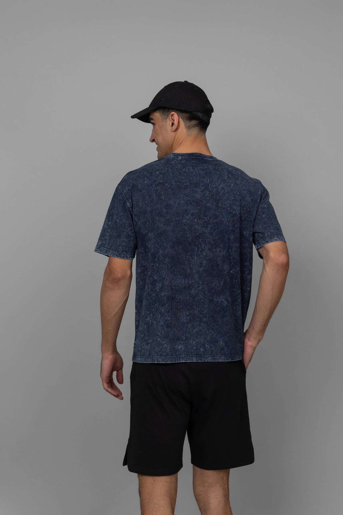 Navy acid wash unisex t-shirt worn by a model from back.