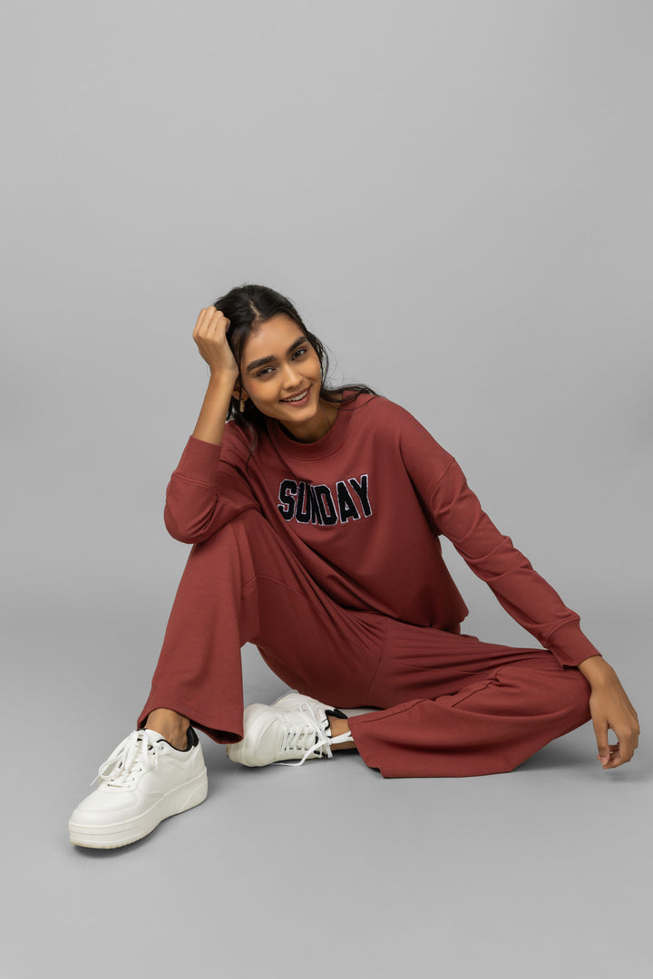 Casual woman wearing Sunday Bamboo Terry Travel Set in maroon.