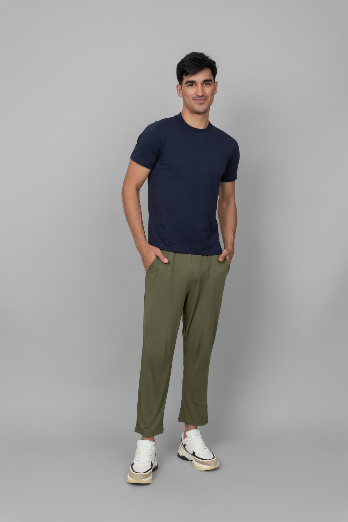 Green men's joggers styled with a navy t-shirt and sneakers.