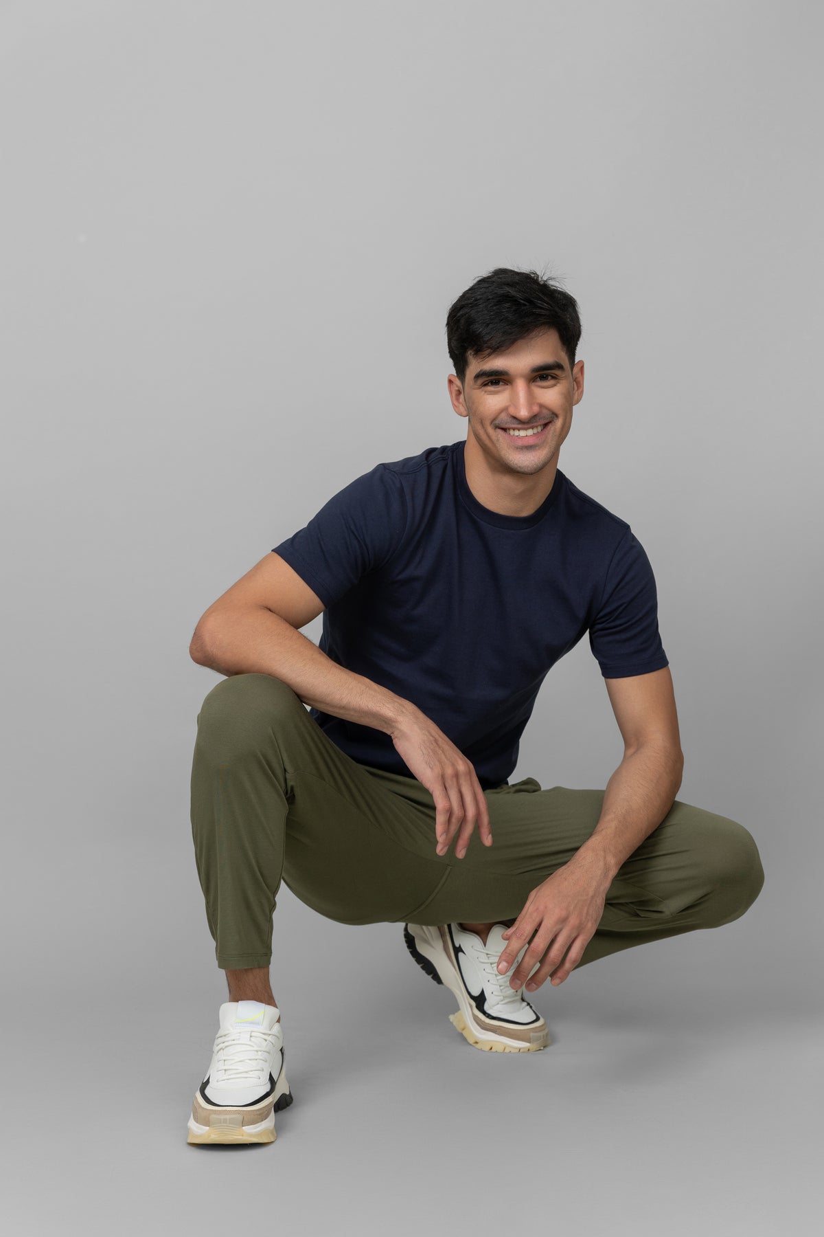 Green men's joggers worn by a smiling model in casual pose.