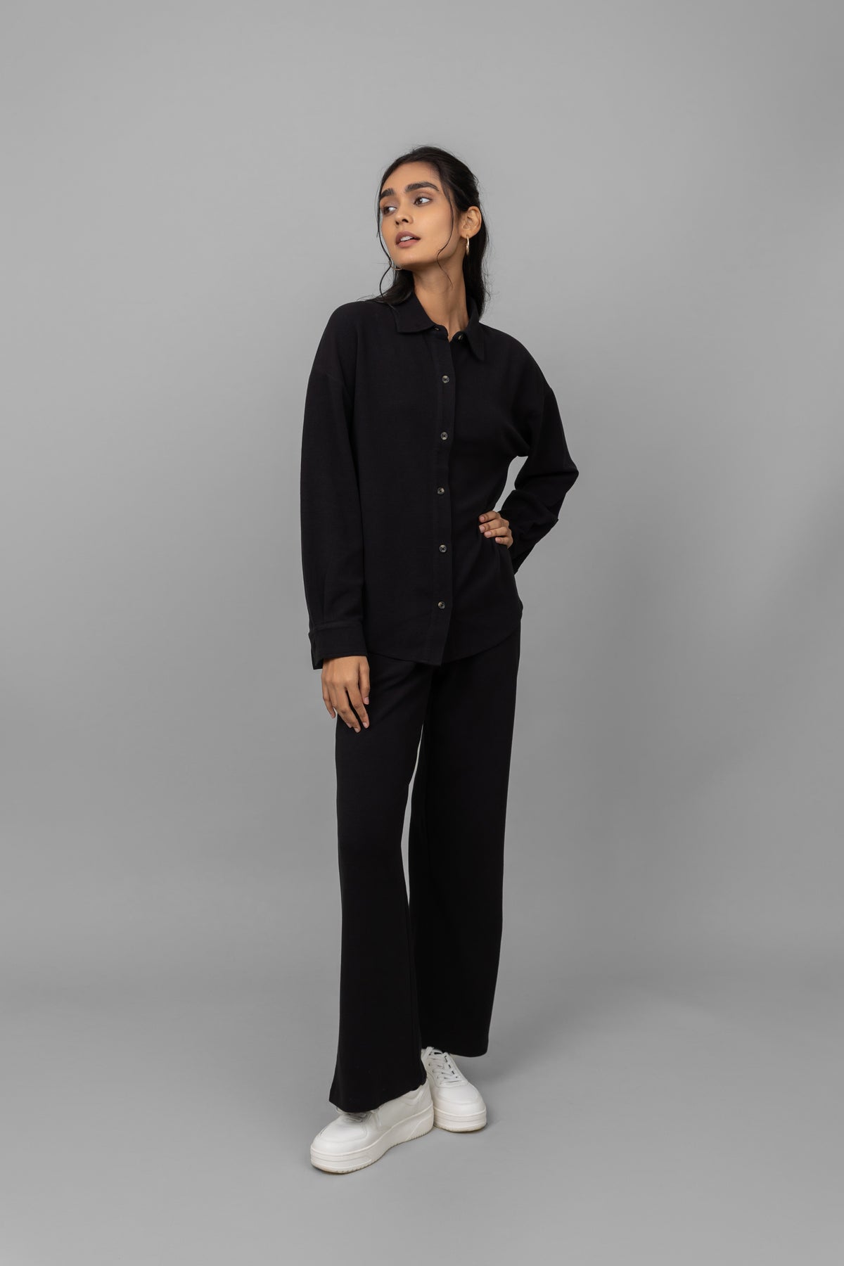 Model wearing black mini waffle multitask pants and stylish white sneakers.