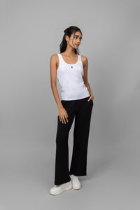 White rib jogger set with tank top, stylish black pants, and sneakers.