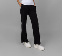 Black Mini Waffle MultiTask Pants modeled with white sneakers on gray background.