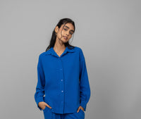 Blue Mini Waffle MultiTask Shirt modeled by a woman against a grey background.