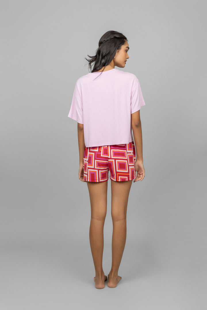 Model wearing Red Zen Shorts with pink top, showcasing stylish back view.