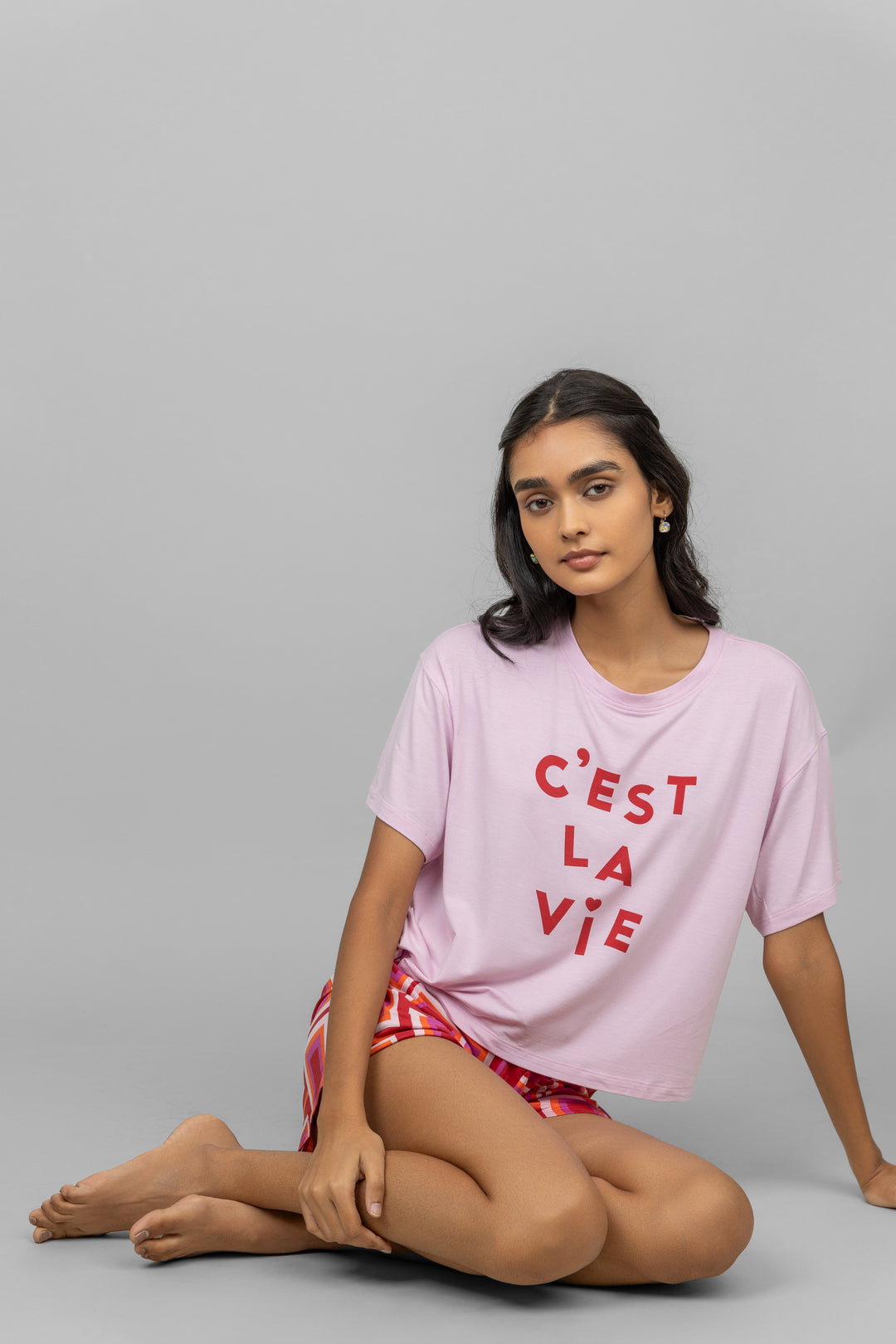 C'est La Vie pink shorts set model sitting stylishly.